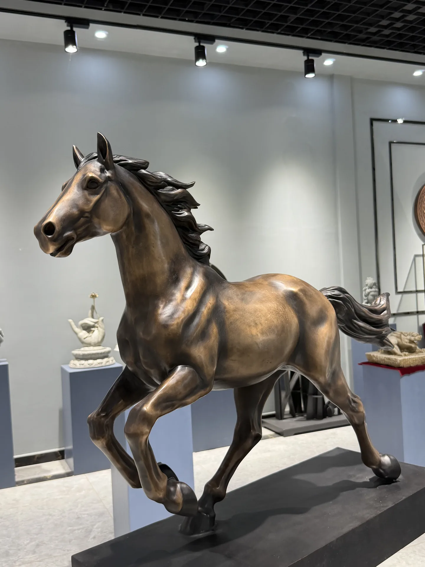 Low-angle view showing the form and patina of a bronze horse sculpture