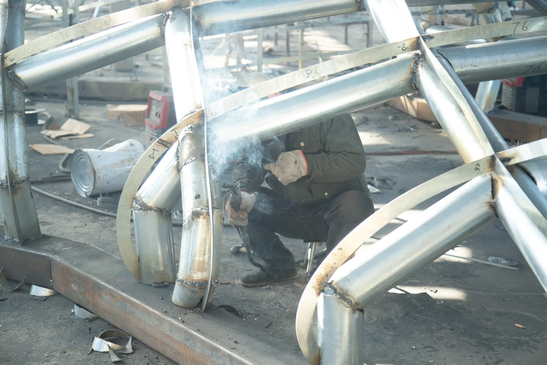Steel sculpture welding with sparks in the Zuvonart fabrication workshop