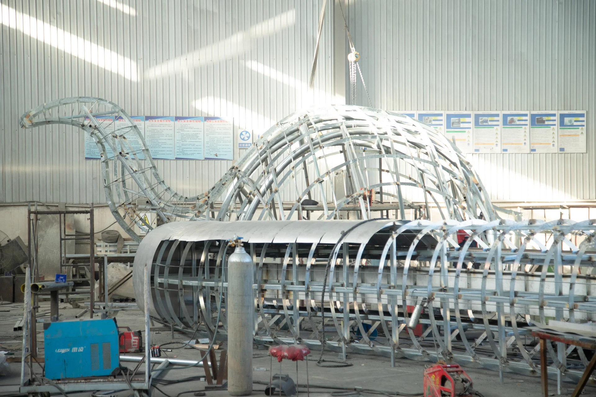 Segmented metal armature for a large sculpture inside the workshop