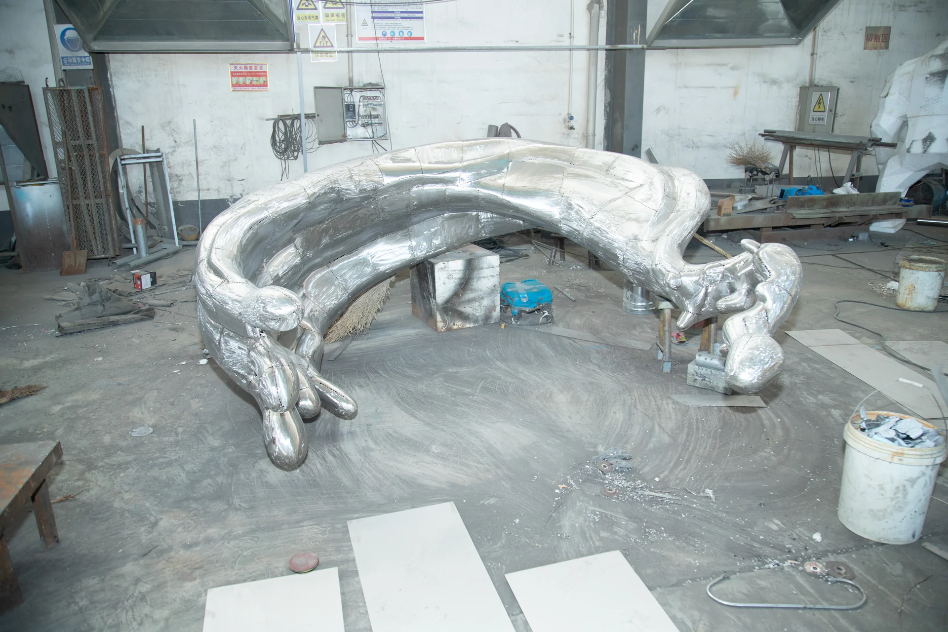 Large stainless steel sculptural form during a late fabrication stage in the workshop