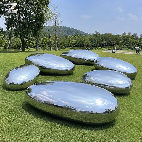 Several rounded reflective pebble-like volumes form a low sculptural cluster.