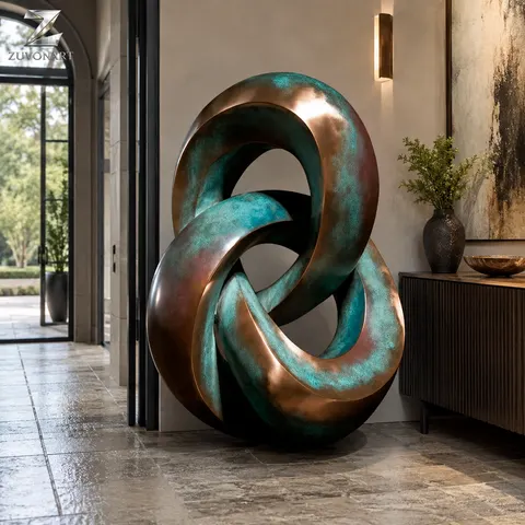 Two rounded linked loops create a compact composition with a patinated surface direction.