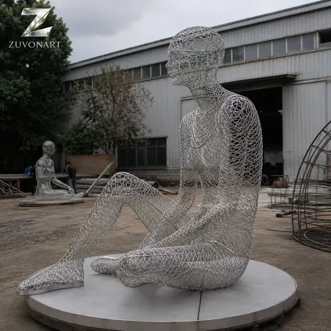 A seated meditative figure is suggested through a translucent wire-mesh surface.